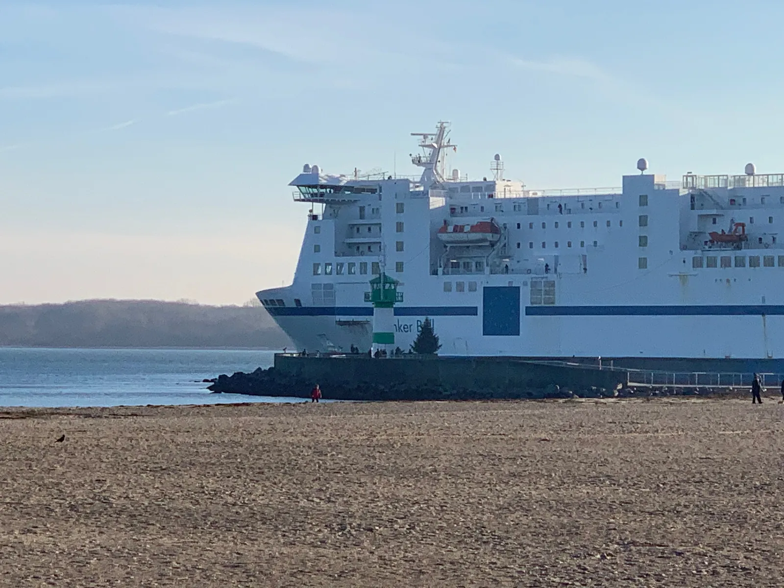 Eine große Fähre fährt an der Nordermole von Travemünde vorbei auf die Ostsee