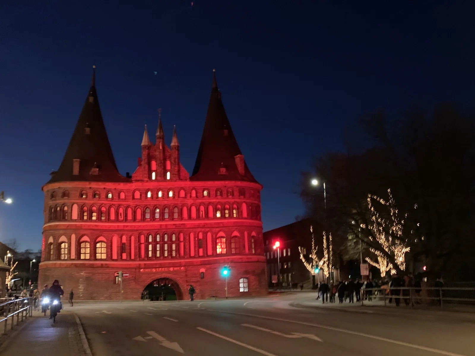 Das Holstentor in Lübeck am Abend, rot angestrahlt