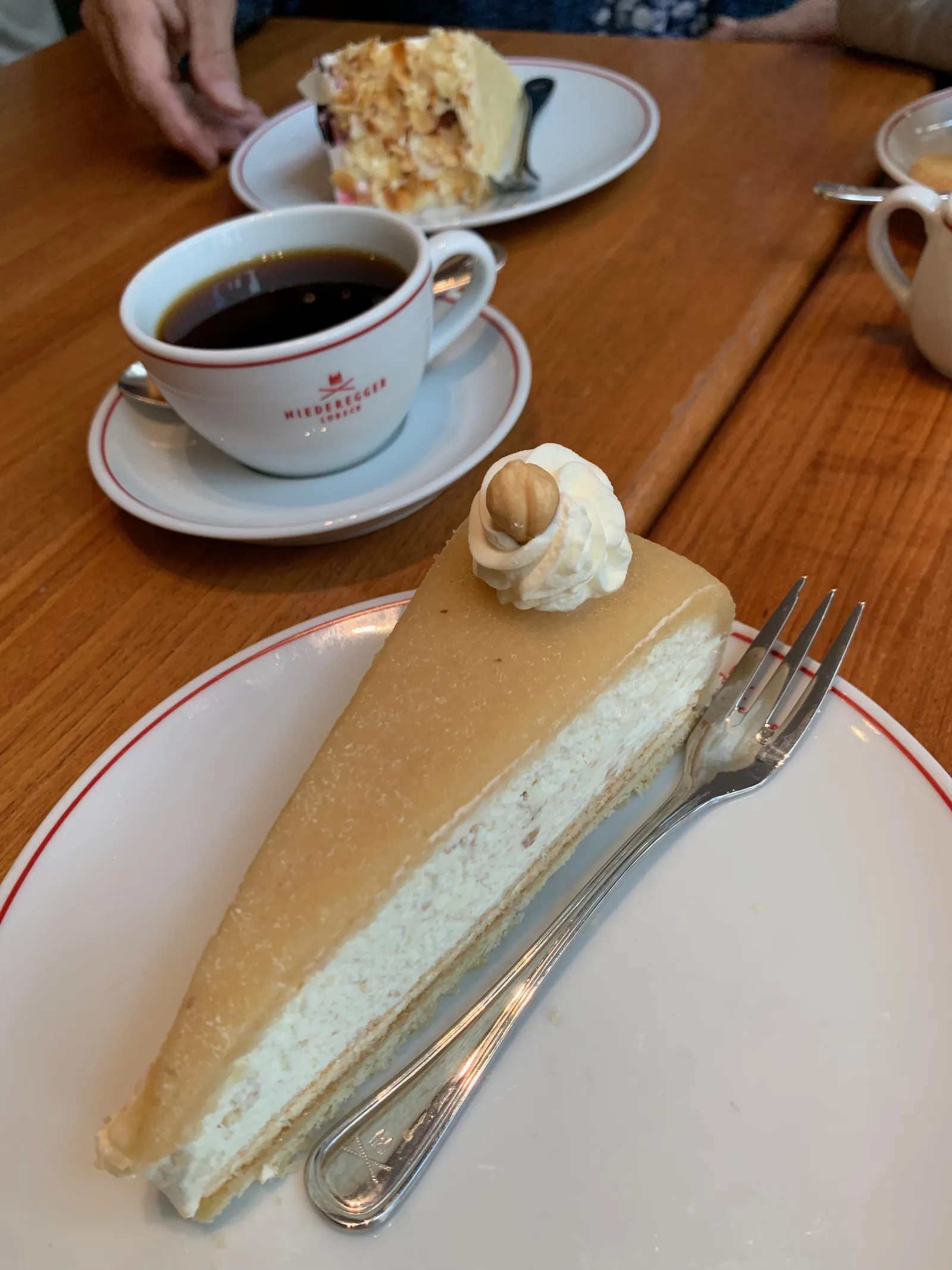Ein Stück Lübecker Nusstorte mit Marzipandecke und eine Tasse Kaffee im Café Niederegger