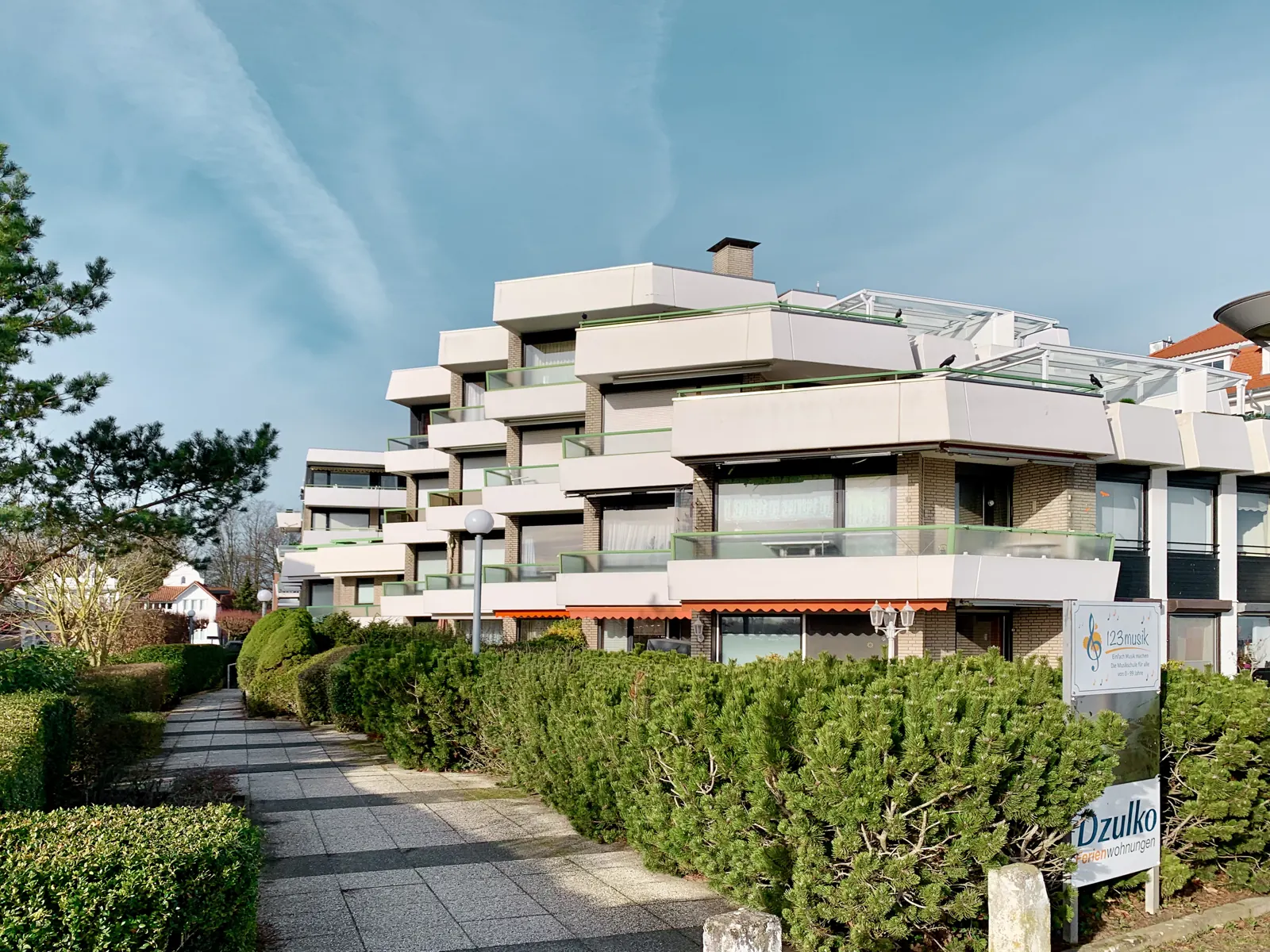 Weg von der Promenade zum Appartementhaus Kaiserallee 2b mit dem Schild von Dzulko Ferienwohnungen