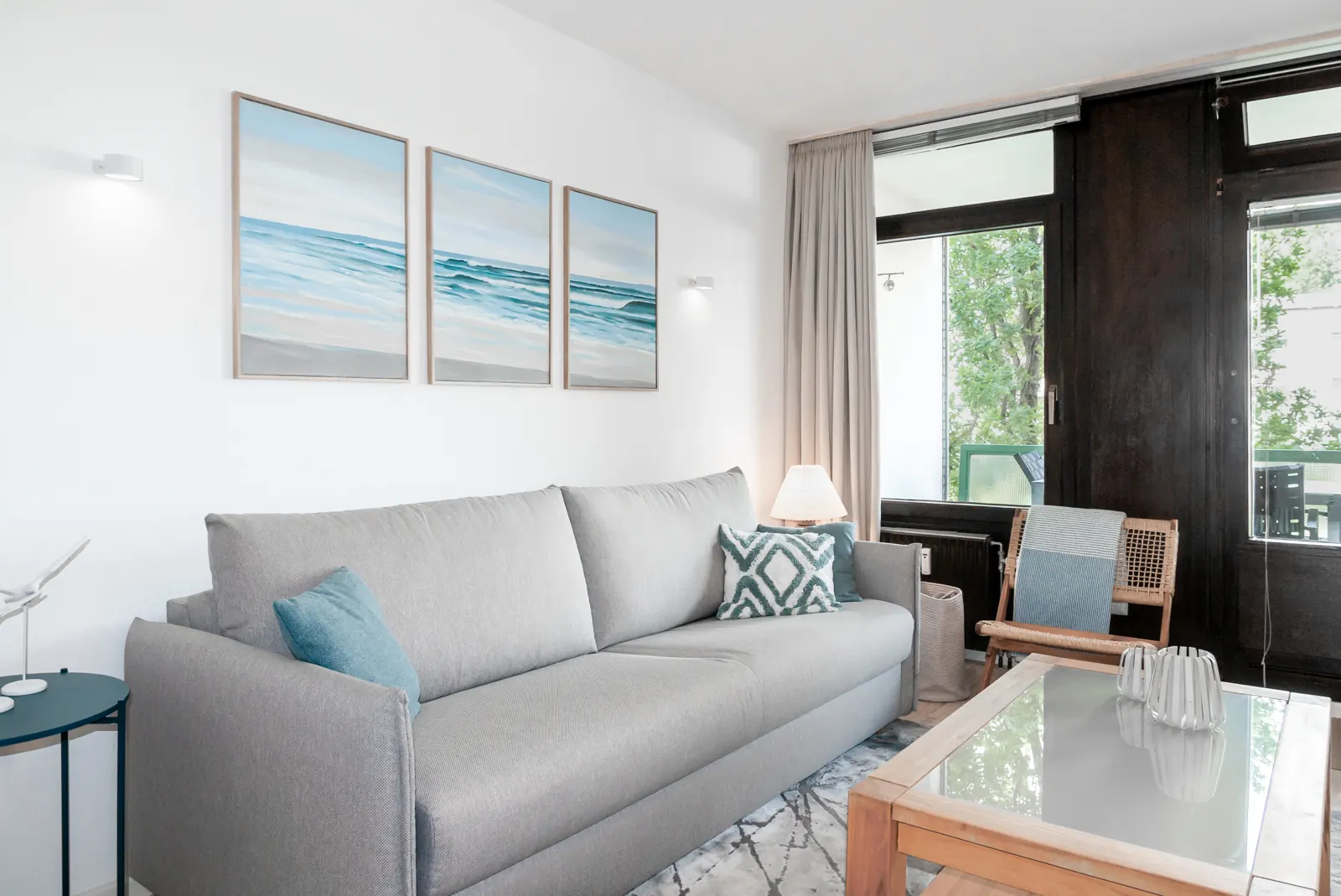 Wohnzimmer der Ferienwohnung mit Sofa, Couchtisch und Blick zur Balkontür